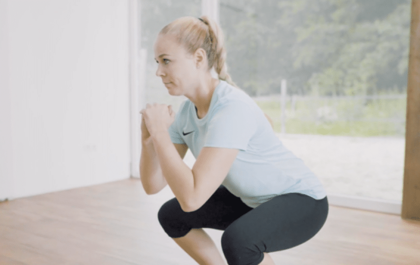 Frau bei stabilisierender Knieübung im Trainingsraum